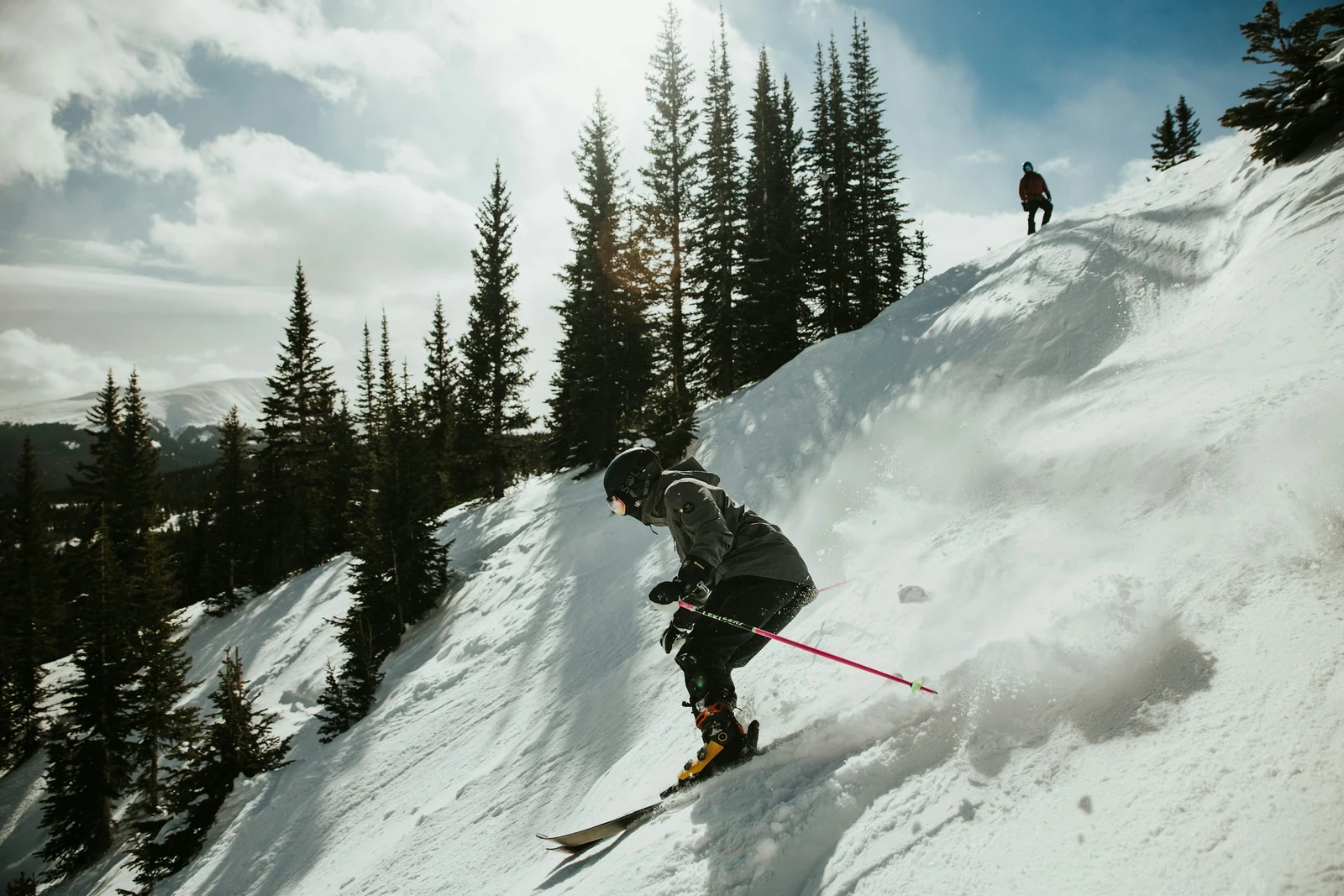 Skier carving through fresh powder on a mountain slope