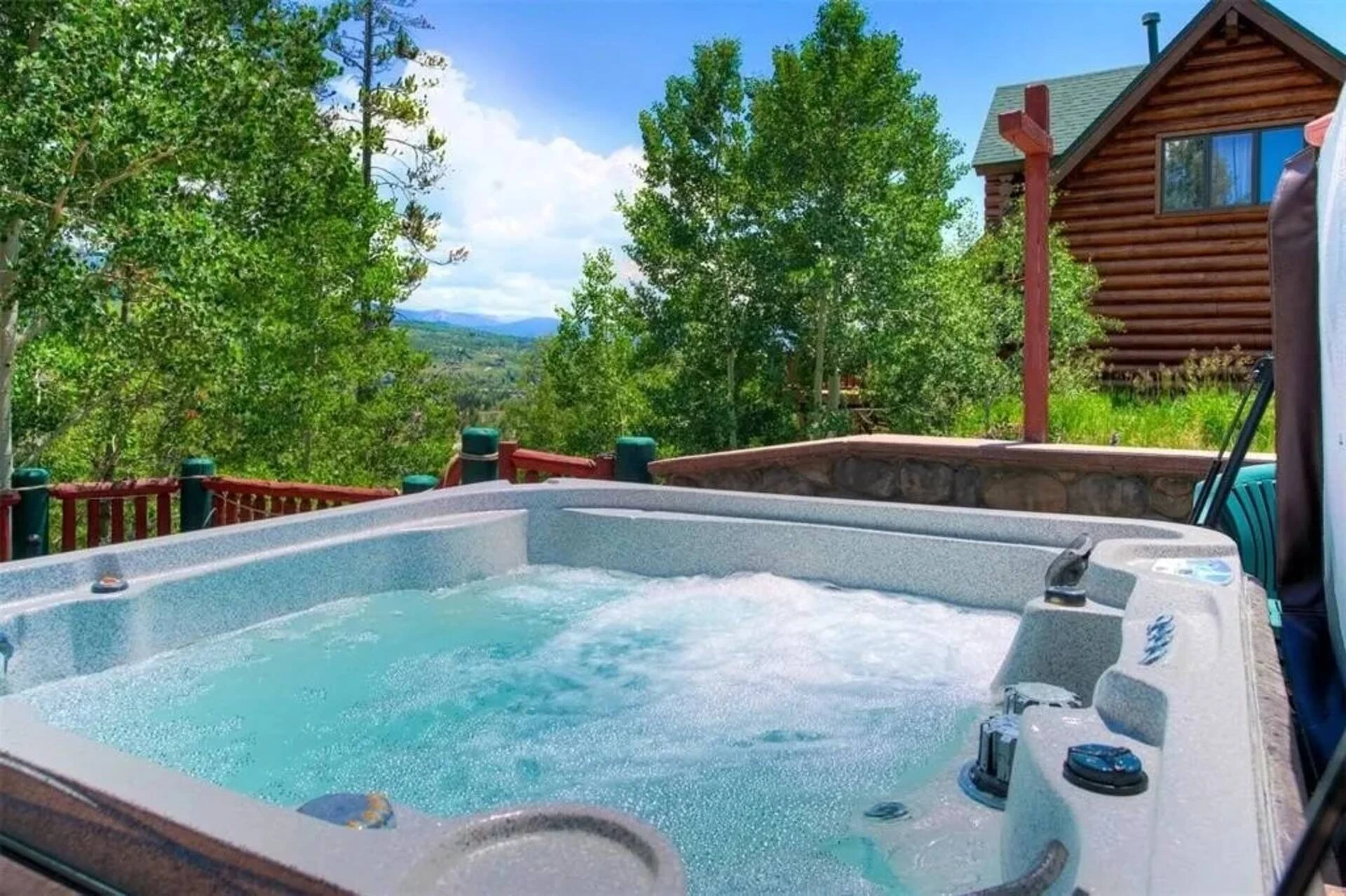Private hot tub on the Lincoln Lodge deck overlooking trees and mountains