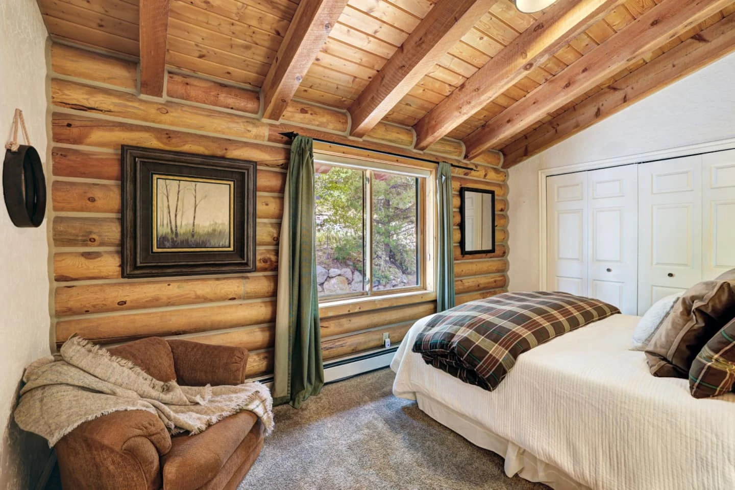 Guest bedroom at Lincoln Lodge with exposed log walls